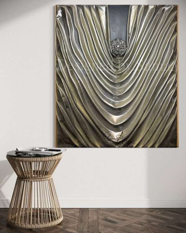 Large silver 3D wall sculpture titled Silver Veils by Samaa, featuring deep metallic fabric-like folds gathered around a central textured sphere on a dark background.